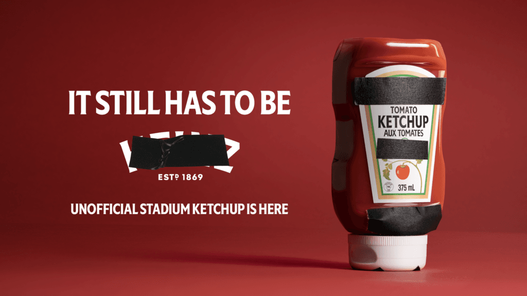 Image – new classic Promotional banner featuring a ketchup bottle with black tape over the label, bold white text on a red background advertising 'Unofficial Stadium Ketchup'.