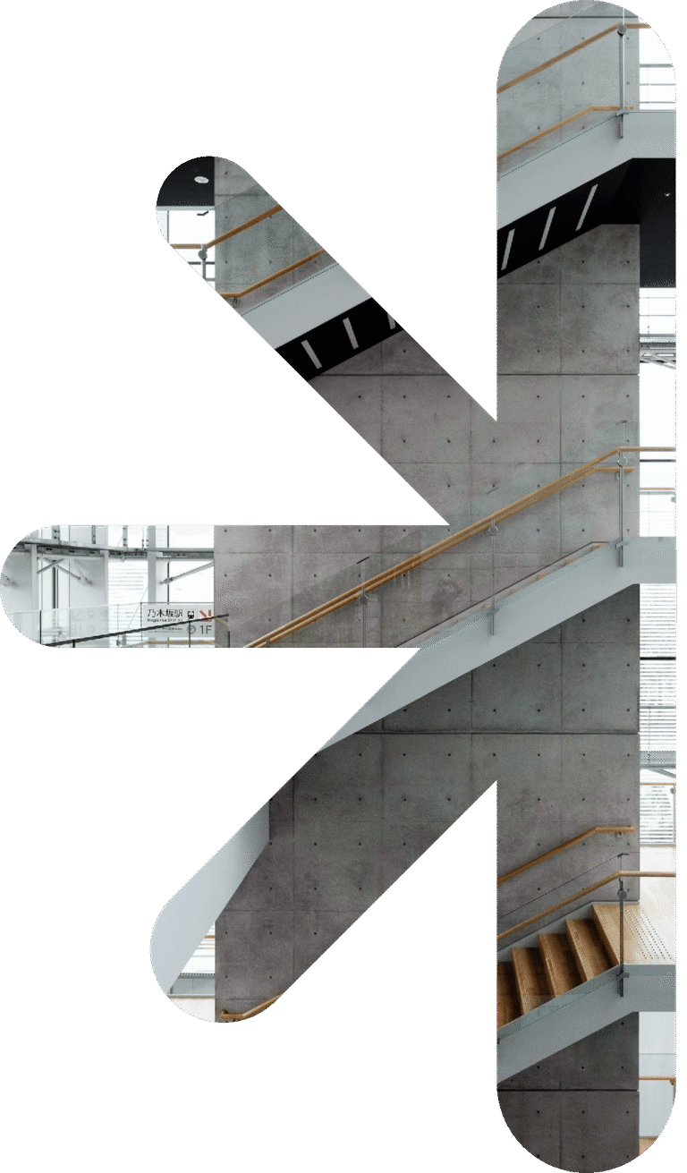 Half logo - place staircase – new classic – new classic Interior of a concrete stairwell with wooden handrails and glass railings.